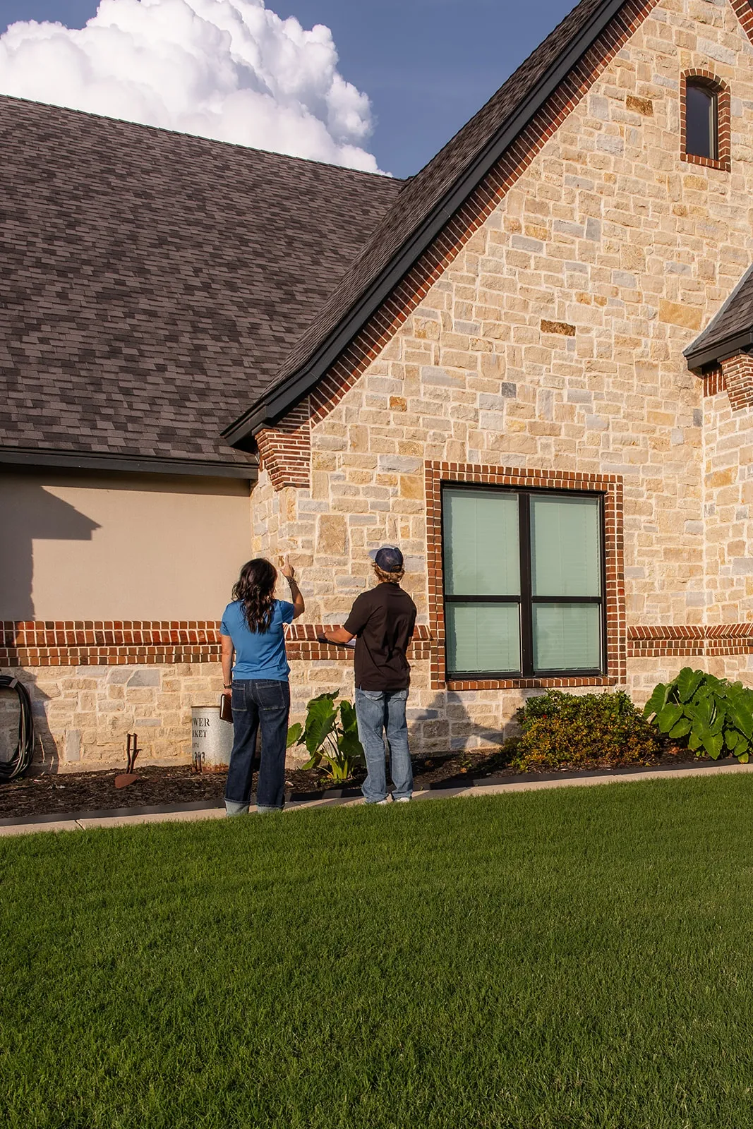 A-Custom team evaluating a home's exterior and roofline for signs of settlement