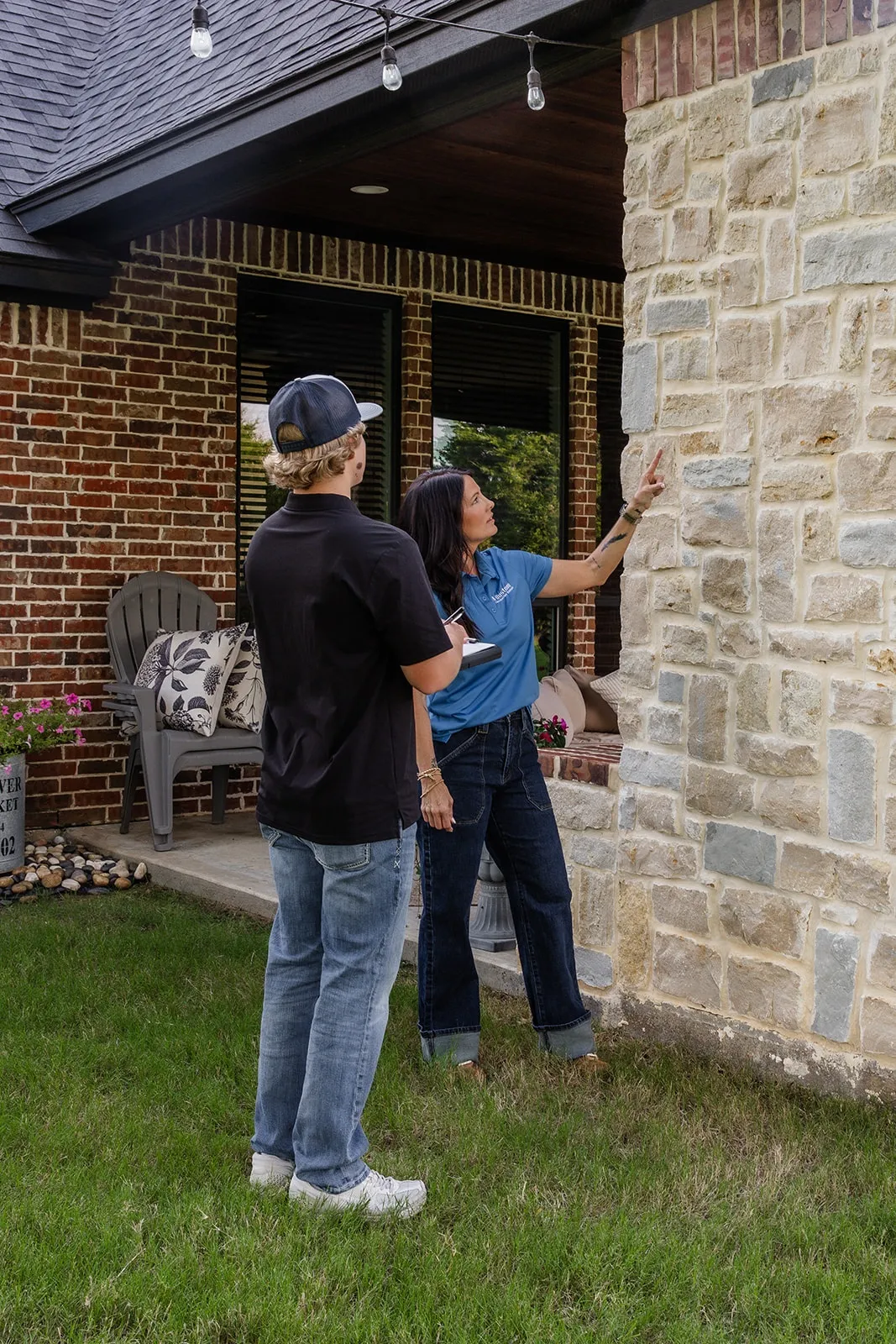 A-Custom team inspecting the stone exterior of a home for foundation movement