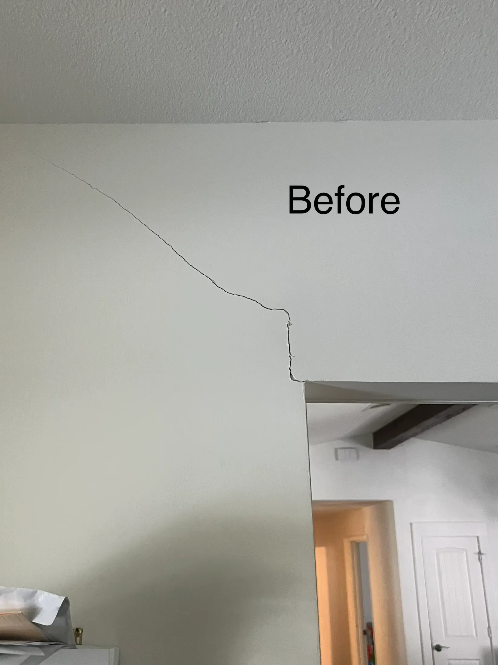 Long crack across an interior drywall corner before foundation repair